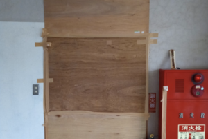 学校の一角に貼られたベニヤ板。スマホねじ込んで撮影した結果・・・ゾッ